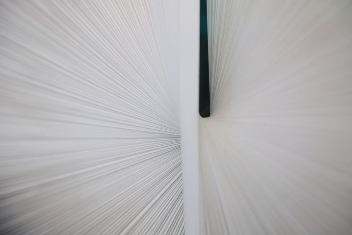 a close up of a white wall with a black pole